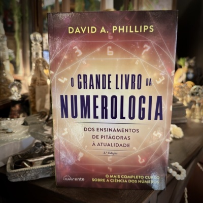 Capa de livro O GRANDE LIVRO DA NUMEROLOGIA num ambiente com objetos decorativos