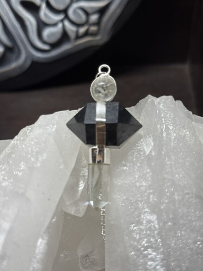Pingente de cristais preto e transparente encostado em cristal branco