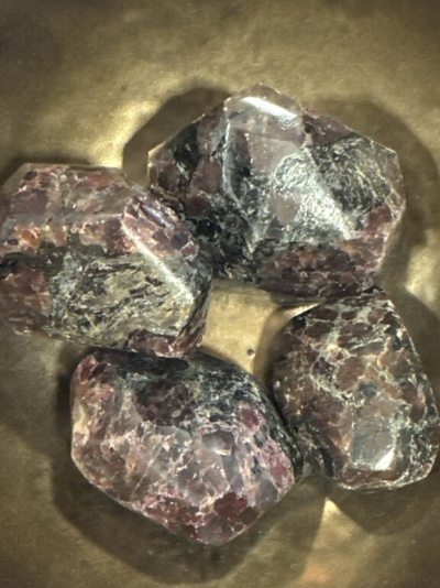 Quatro pedras polidas coloridas sobre superfície dourada