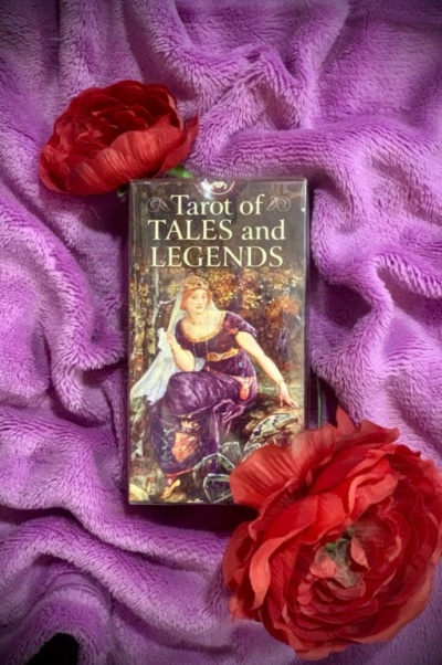 Baralho de Tarot Tarot of TALES and LEGENDS sobre tecido lilás com flores vermelhas