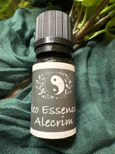 Frasco de óleo essencial de alecrim sobre tecido verde