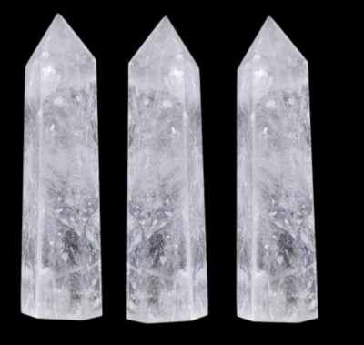 Três obeliscos de cristal transparente sobre fundo preto
