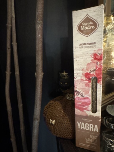 Caixa de incenso Sagrada Madre Yagra com fragrância de rosa e baunilha num ambiente rústico.