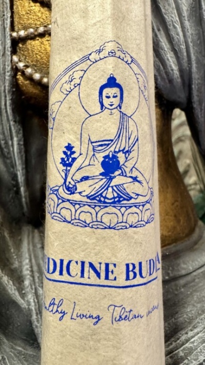 Embalagem com imagem azul de Buda sentado em papel bege