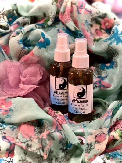 Dois frascos de spray Alfazema sobre tecido floral colorido com flor rosa