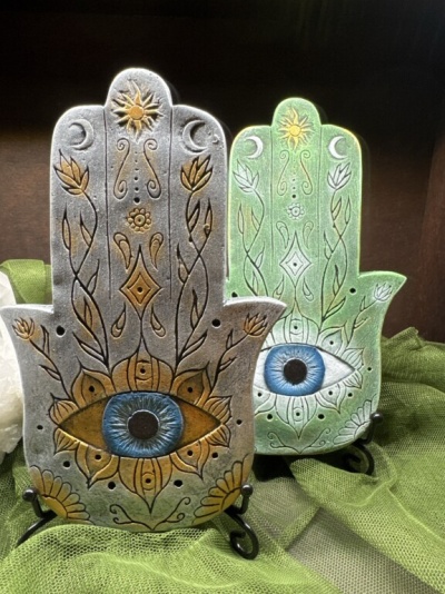 Dois pendurais Hamsa decorativos com olhos azuis e detalhes dourados e brancos