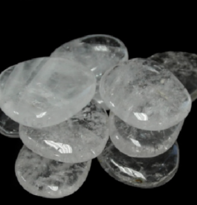 Pedras de cristal transparente polidas e ovais sobre fundo preto