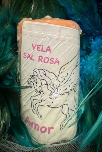 Vela de sal rosa com rótulo e ilustração de unicórnio alado em meio a penas coloridas