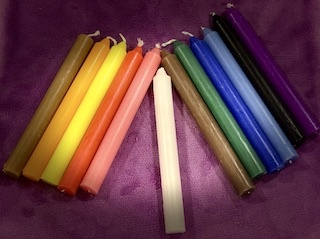 Conjunto de velas coloridas sobre tecido roxo