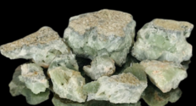 Pedaços de pedra mineral verde com manchas brancas sobre fundo preto