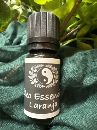Frasco pequeno de óleo essencial de laranja com rótulo preto e branco e símbolo yin-yang