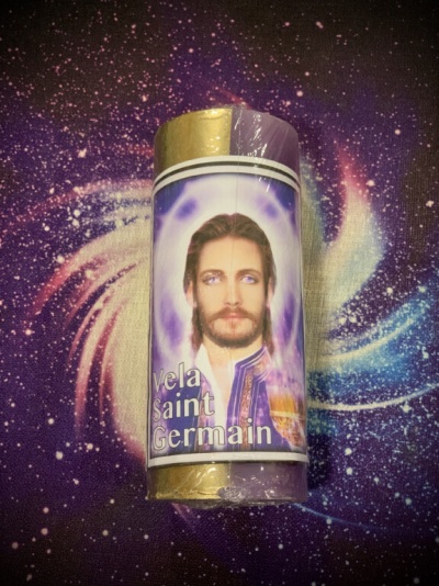 Vela Saint Germain metade dourada e roxa com rosto de homem na etiqueta