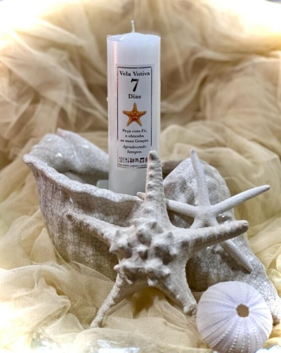 Vela votiva branca com estrelas do mar decorativas e recipiente branco texturizado