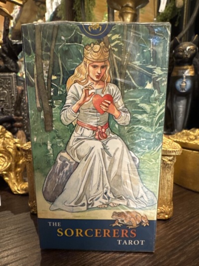 Caixa de baralho de tarot com figura sentada e texto The Sorcerers Tarot