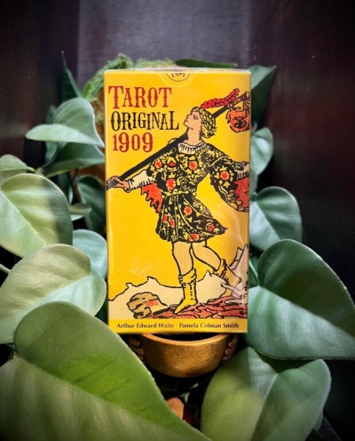 Caixa amarela de Tarot Original 1909 com figura humana e folhas verdes ao redor