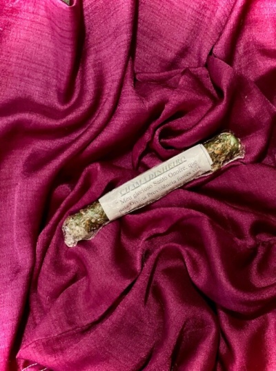 Vela artesanal com etiqueta sobre tecido de veludo vinho
