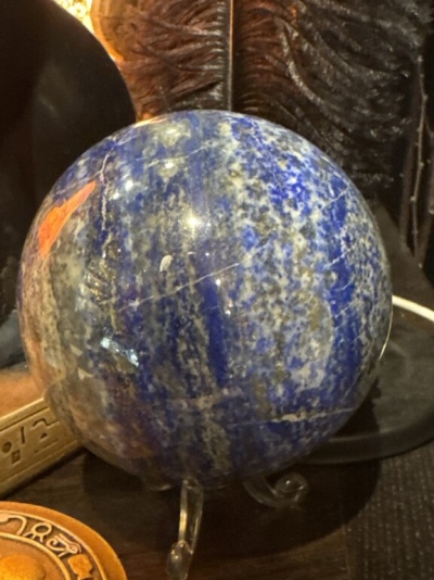 Esfera decorativa de pedra azul e branca sobre base transparente