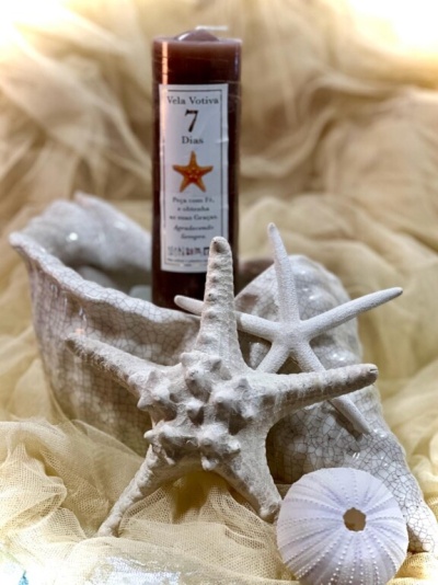 Vela votiva castanha com texto e estrelas-do-mar decorativas brancas