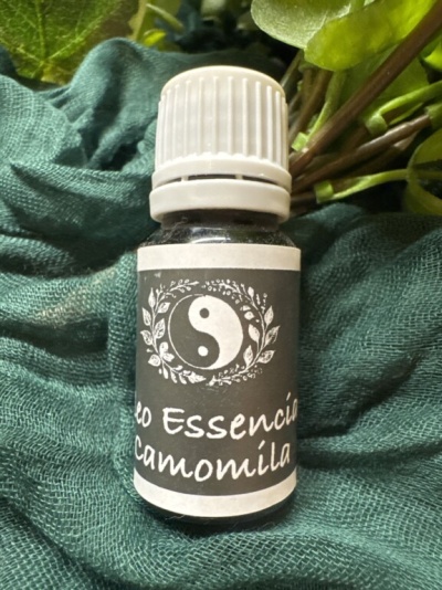 Frasco de óleo essencial de camomila com rótulo cinza e texto em branco.