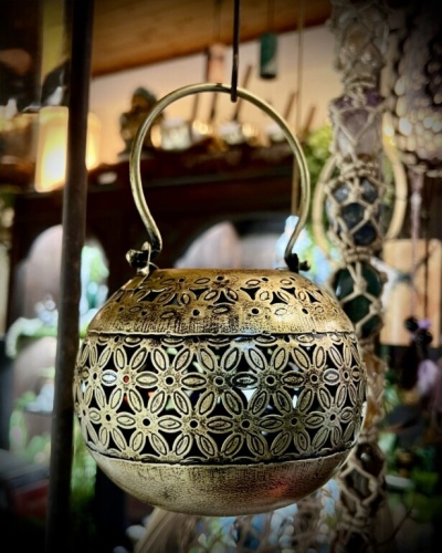 Lanterna decorativa dourada em metal com padrão floral recortado suspensa