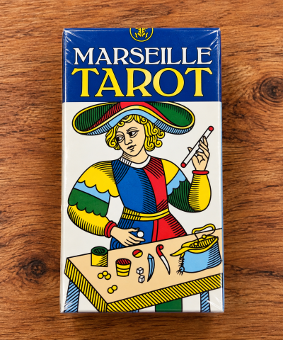 Caixa de baralho Marseille Tarot com ilustração colorida de personagem e texto