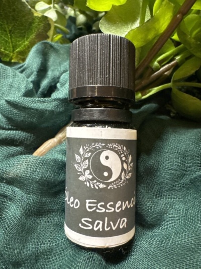 Frasco de óleo essencial com rótulo preto e símbolo yin-yang sobre tecido verde