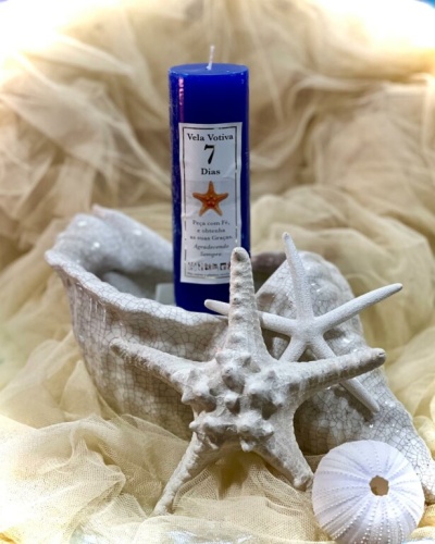 Vela votiva azul com estrela do mar em concha branca e elementos marinhos brancos
