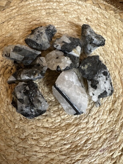 Pedras minerais brancas e pretas sobre tapete trançado