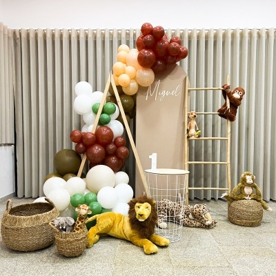 Decoração festa infantil com balões, painel nome Miguel, peluches de animais e cestos de verga