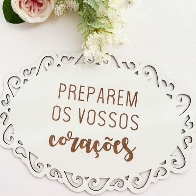 Placa decorativa branca com texto em castanho e flores artificiais cor-de-rosa e brancas