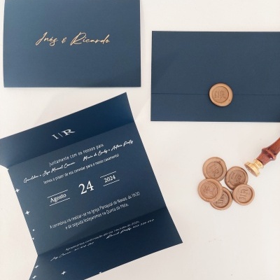 Convite de casamento azul escuro com selo de cera castanho e texto branco