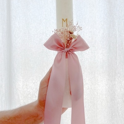 Vela branca com laço rosa e flores secas