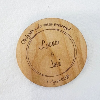Disco redondo de madeira clara com gravação a laser com texto em português.