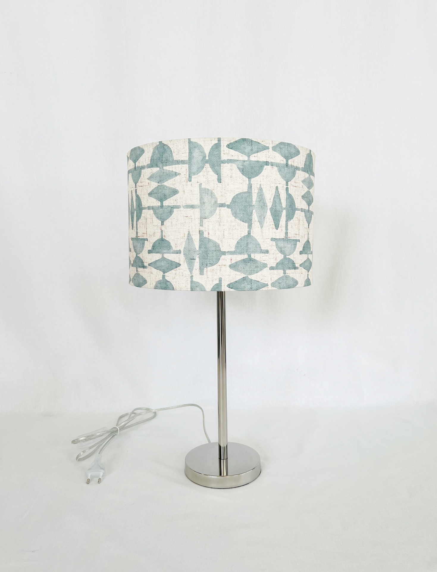 MF0018AB30 Candeeiro de mesa com cúpula bege com padrão azul e base metálica prateada.