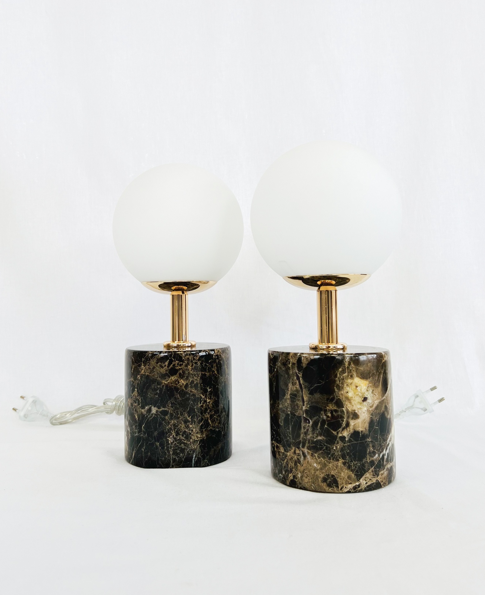 MF020 Duas lâmpadas de mesa com base em mármore preto, haste dourada e cúpula branca esférica