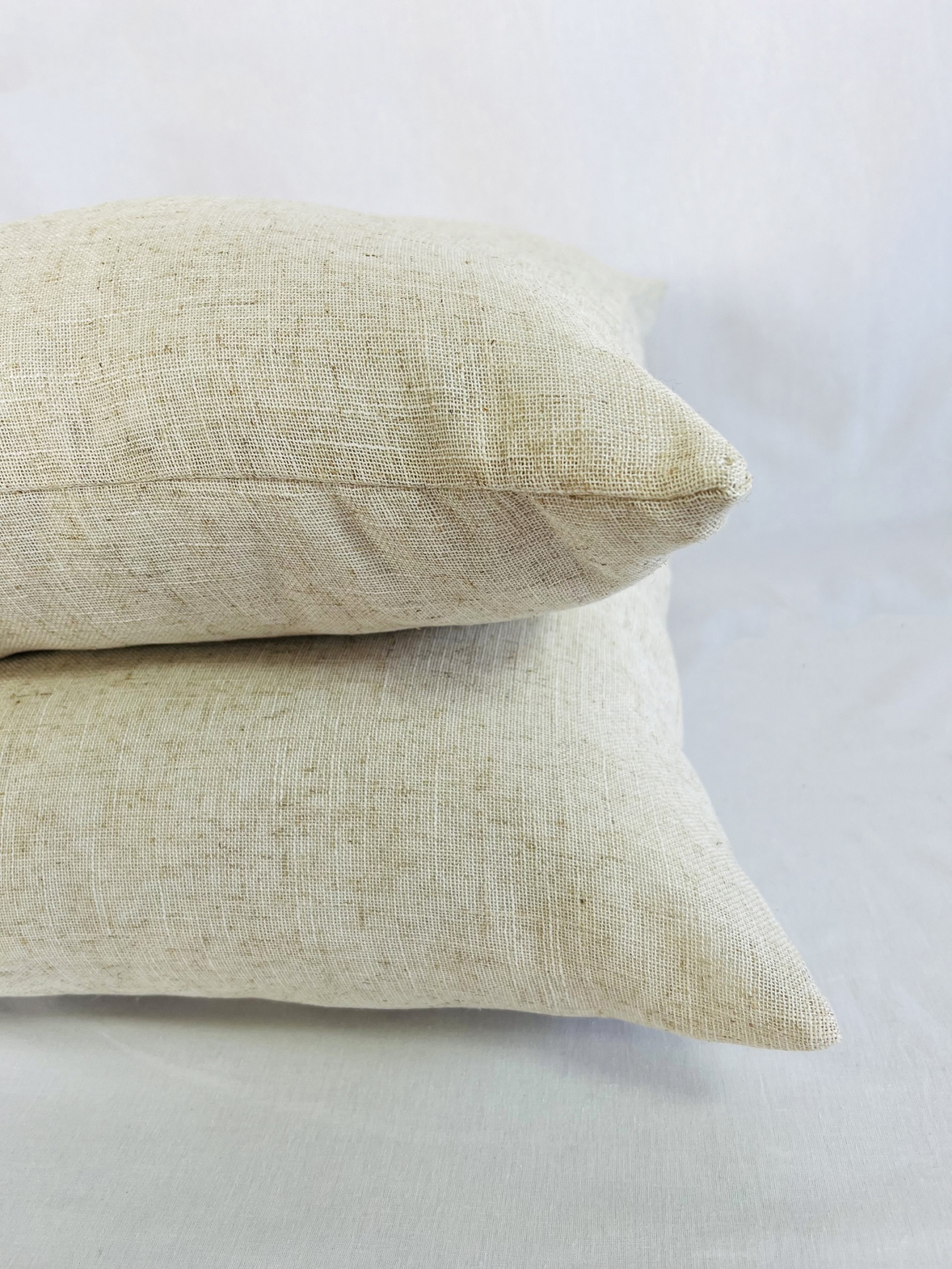 AL6060Indie Duas almofadas bege claro empilhadas sobre superfície clara