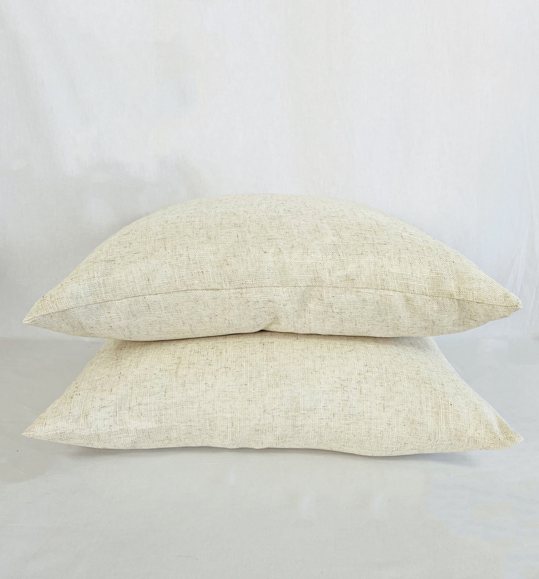 AL6060Indie Duas almofadas creme claras empilhadas sobre fundo branco