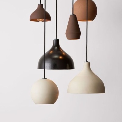 Conjunto de cinco candeeiros suspensos de várias formas e cores em tons terra e preto