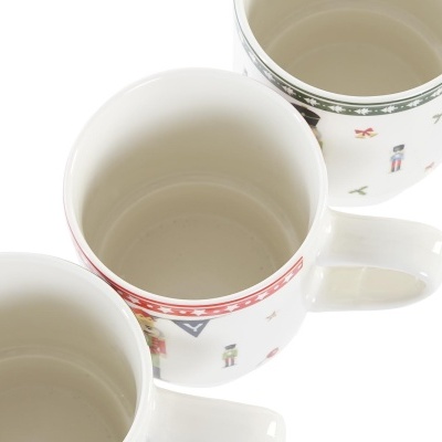 Três canecas de cerâmica branca com padrões decorativos no topo e desenhos coloridos na superfície exterior