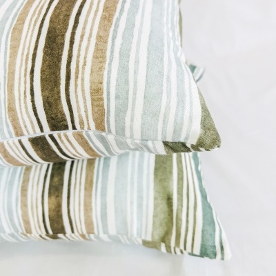 Almofadas com padrão de riscas verdes, bege e azul claro