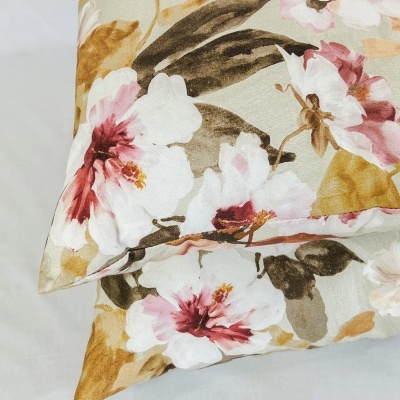 Almofadas florais em tecido bege com detalhes em rosa e castanho