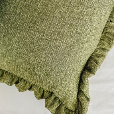 Almofada verde com borda ondulada sobre fundo branco