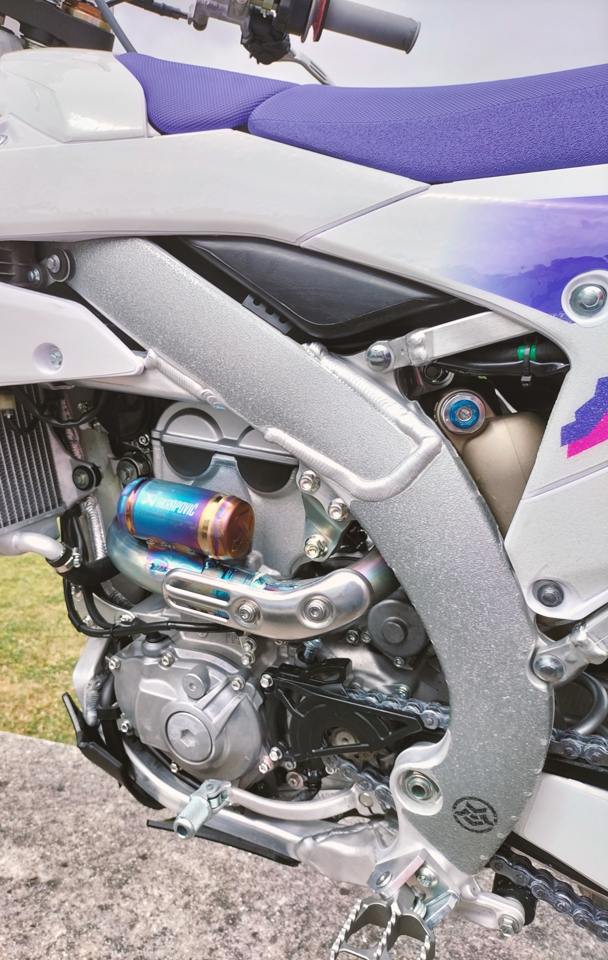 KIT ADESIVOS P/ QUADRO - YAMAHA YZ450F 2023-2025 Motor e estrutura de moto branca com assento roxo e escapamento AKRAPOVIC