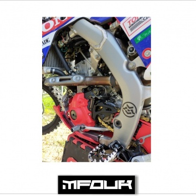 Parte do motor de uma moto off-road com quadro prateado e cobertura vermelha