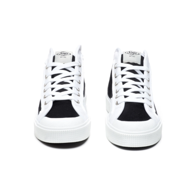 Sapatilhas pretas e brancas com atacadores brancos e sola branca.