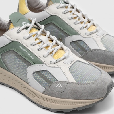 Sapatilhas desportivas com mesh transparente em cinza, branco, verde e amarelo.