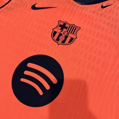 Camisola laranja com logótipos do FC Barcelona e Nike em preto e padrão com número 1899.