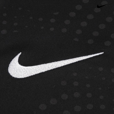 Tecido preto com padrão bolinhas e logotipo Nike branco bordado.