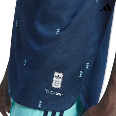 Parte inferior de t-shirt desportiva azul escura com padrões geométricos claros e etiquetas visíveis.