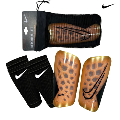 Caneleiras Nike douradas Mercurial Lite com manguitos pretos e símbolo Nike.